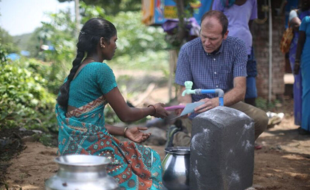 Gary White speaks to a Water.org borrower near Kancheepuram, India.